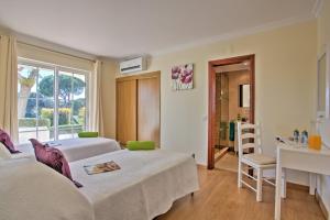 ヴァーレ・ド・ローボにあるVilla Beirais by Villa Plusのベッド2台と机と窓のある寝室 +30枚の写真