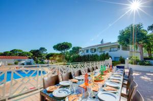 ヴァーレ・ド・ローボにあるVilla Beirais by Villa Plusの長テーブル(皿、グラス付)が備わるパティオ