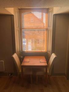 a table and chairs in a room with a window at Immaculate 1 Bed Apartment in Pitlochry Scotland in Pitlochry