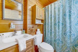 a bathroom with a toilet and a sink and a shower at Yosemite Mountain Cottage in Groveland