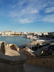 a person walking on a sidewalk next to a body of water at Casa Relax vicino a Otranto in Giurdignano