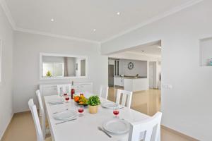 une salle à manger blanche avec une table et des chaises blanches dans l'établissement Villa Pianda by Villa Plus, à Almancil