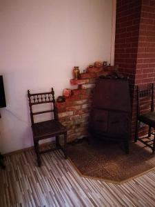 a living room with two chairs and a brick fireplace at Pas Ligita in Biržai