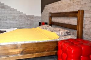 a bedroom with a bed and a red ottoman at Апартаменты ПРЕМЬЕР in Kamianets-Podilskyi