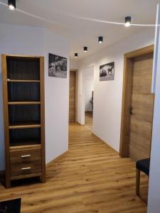 a room with a hallway with wooden floors and a door at Ferienwohnung Staudach, Apartment in Fügenberg