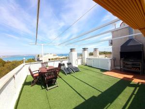 patio con mesa y sillas en el balcón en Barbacoa + vistas al mar + playa + piscina. en Salou