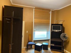 a living room with a tv and a window at Hotel Restaurant Frankenturm in Trier