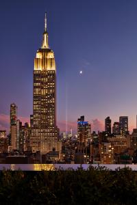 a tall building lit up at night in a city at Hotel Hendricks in New York