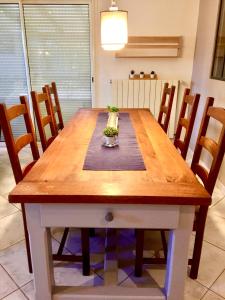 uma mesa de jantar em madeira com cadeiras à volta em Résidence Alpha Centauri em Carcassonne