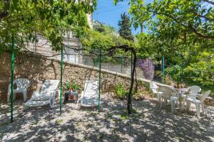 eine Gruppe von Stühlen und Tischen unter einem Baum in der Unterkunft MILKA-sea view apartment in center in Dubrovnik