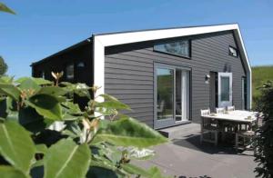 a tiny house with a patio and a table at Diek42 in Kattendijke