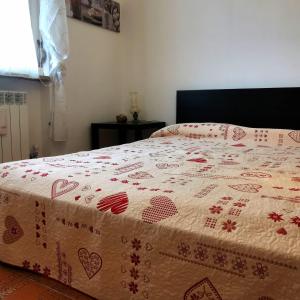 Una cama con un edredón rojo y blanco. en Appartamento Chatillon, en Châtillon