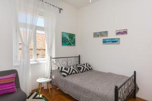 ein Schlafzimmer mit einem Bett, einem Fenster und einem Stuhl in der Unterkunft MILKA-sea view apartment in center in Dubrovnik