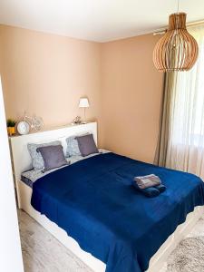 - une chambre avec un lit et une couverture bleue dans l'établissement Kolka, à Kolka