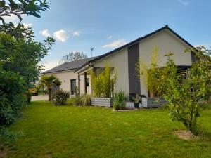 a house with a green yard in front of it at La Zénitude chambre d hôte in Chamarandes