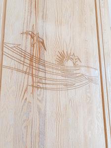 un dessin d'un bateau sur une table en bois dans l'établissement Kolka, à Kolka