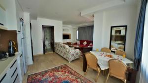 a kitchen and a living room with a table and chairs at Cozy and Luxury Apartment in Amazing Facility in Belek