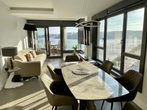 a living room with a table and chairs and a couch at Luxury boutique playa Silgar in Sanxenxo