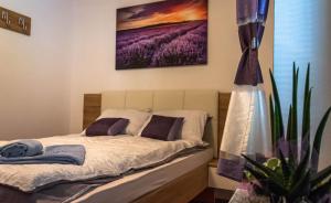 a bedroom with a bed and a painting on the wall at Hiša Bohinc z wellnessom in Tolmin