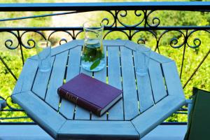 a blue table with a book and a wine glass at REMVI Apartments Assos in Asos