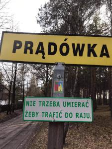 a yellow sign on a pole next to a road at Agroturystyka PLENER in Miedzichowo