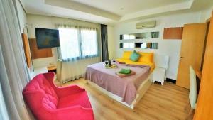 1 dormitorio con 1 cama y 2 sillas rosas en Cozy and Luxury Apartment in Amazing Facility, en Belek
