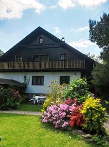 dom z drewnianym dachem i kwiatami w obiekcie CHALUPA OSTRAVICE w Ostrawicy