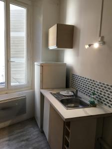 a small kitchen with a sink and a window at Le Victor HUGO 1G et sa pizza offerte in Aurillac