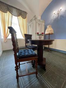 um quarto com uma mesa e cadeiras, uma mesa e um candeeiro em Dvoulůžkový pokoj Blue Grace na zámku em Česká Kamenice