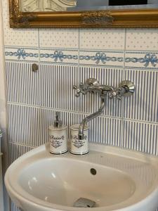 a bathroom sink with a faucet and two cans on it at Dvoulůžkový pokoj Blue Grace na zámku in Česká Kamenice