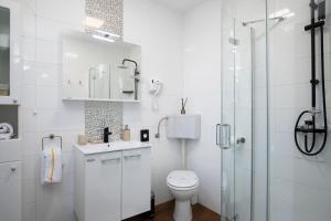 a white bathroom with a toilet and a glass shower at House ingrid in Pula +29 photos