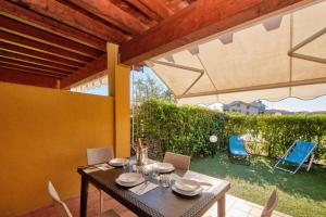 un patio con mesa, sillas y sombrilla en Casa MaJA, en Desenzano del Garda