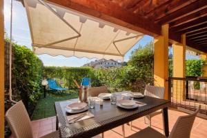 une terrasse avec une table, des chaises et un parasol dans l'établissement Casa MaJA, à Desenzano del Garda