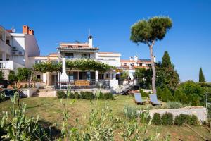 a house with a tree and chairs in the yard at House ingrid in Pula