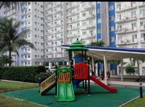 um parque infantil em frente a um grande edifício em The Grass Residences em Manila