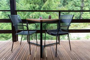 three chairs and a table on a porch with a table and chairs at Парк-готель Щастя in Skhidnitsa