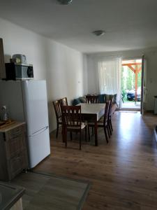 a kitchen and dining room with a table and a refrigerator at Vivienne Apartment in Zamárdi