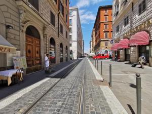 ulica z torami kolejowymi w mieście z budynkami w obiekcie Hotel Millerose w Rzymie
