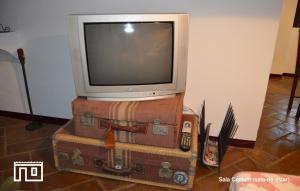 un televisor sentado en la parte superior de las maletas con un televisor en la parte superior en Casinha de Montoito, en Montoito