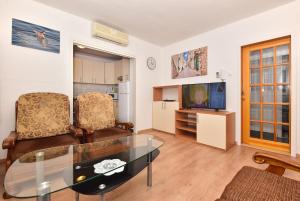 sala de estar con mesa de cristal y sillas en Apartments Vjeko, en Makarska