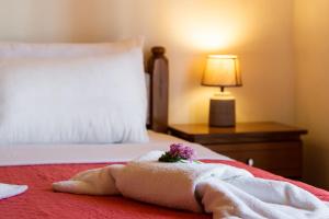 a hotel room with a towel and flowers on a bed at Delphinus Villa Nefeli in Agios Nikitas