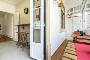 Cette chambre dispose d'un couloir avec une table et une horloge. dans l'établissement classy and modern amzing double Room Retro in Central Lisbon, With shared Bathroom, à Lisbonne