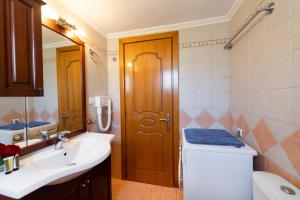 a bathroom with a sink and a toilet and a mirror at Delphinus Villa Nefeli in Agios Nikitas