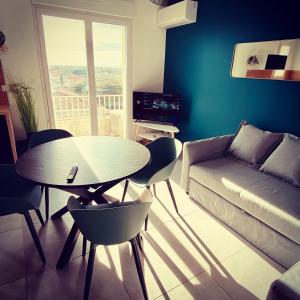 a living room with a table and a couch at "ZEN" 100m de la plage avec parking, vue mer et vue montagne in Canet-en-Roussillon