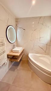 La salle de bains est pourvue d'une baignoire, d'un lavabo et d'un miroir. dans l'établissement "ZEN" 100m de la plage avec parking, vue mer et vue montagne, à Canet