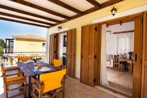 a room with a table and chairs on a balcony at Delphinus Villa Nefeli in Agios Nikitas