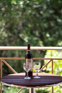 a bottle of wine and two glasses on a table at Delphinus Villa Nefeli in Agios Nikitas