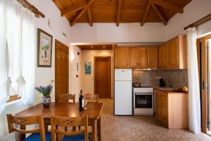 a kitchen with wooden cabinets and a table with chairs at Delphinus Villa Nefeli in Agios Nikitas
