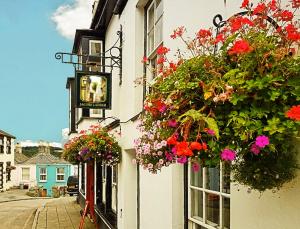 a building with flowers hanging on the side of it at Jacobs Ladder Inn in Falmouth