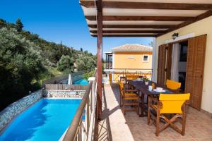 a patio with a table and chairs next to a swimming pool at Delphinus Villa Nefeli in Agios Nikitas